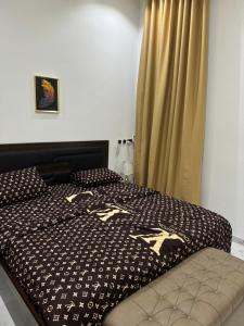 ein Bett mit einer schwarzen und weißen Bettdecke mit goldenen Pferden darauf in der Unterkunft Three bedroom duplex at chevron lekki, Lagos in Lekki
