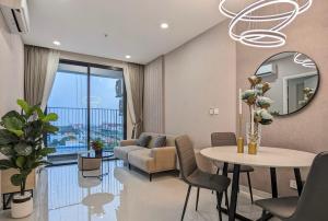 a living room with a couch and a table and a mirror at The Emerald Golf View in Thuan An