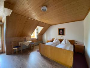 a bedroom with a bed and a table in a room at Bauernhof Helpferer in Ramsau am Dachstein