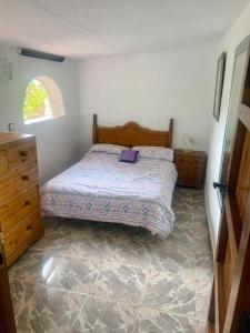 a bedroom with a bed and a dresser and a window at Cute Little Casita in Mijas