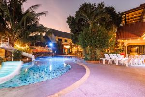a swimming pool with white chairs and a resort at Phuniphat Pool Villa in Nong Prue