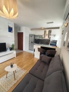 a living room with a couch and a kitchen at Beach Pearl Apartment in Split