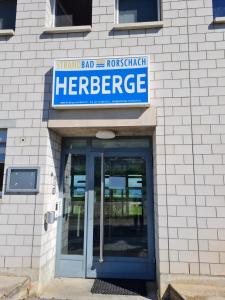 um sinal sobre a entrada de um hospital de surtos de herpes em Herberge-Unterkunft-Seeperle in Rorschach em Rorschach