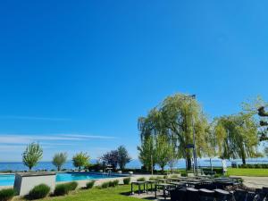 a resort with a swimming pool with tables and chairs at Herberge-Unterkunft-Seeperle in Rorschach in Rorschach