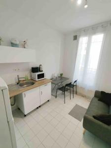 a kitchen and living room with a couch and a table at Cozy Polo's House in Bagnolet