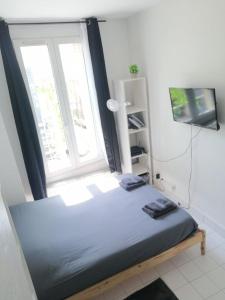 a bed in a room with a large window at Cozy Polo's House in Bagnolet +2 photos