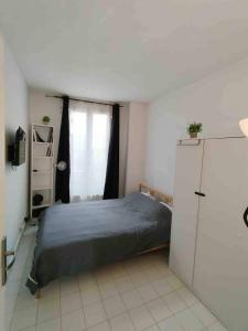 a bedroom with a bed and a refrigerator at Cozy Polo's House in Bagnolet