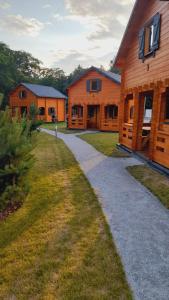 a walkway leading to two wooden buildings at Osada Gardenia in Ślesin