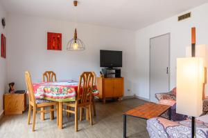 a dining room with a table and chairs and a tv at Maisonnette Chez Georges in Metzeral