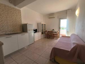 una cocina con armarios blancos y una mesa con mesa en Jet Residence Agenzia Riviera del Conero, en Porto Recanati