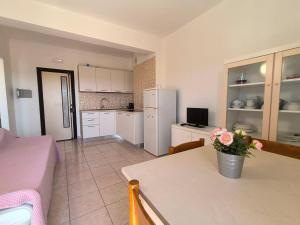 a kitchen with a table with a vase of flowers on it at Jet Residence Agenzia Riviera del Conero in Porto Recanati