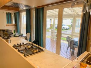 a kitchen with a stove and a view of a yard at Mobil-home CAMARGUE in Vias