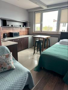 チェンストホヴァにあるApartamenty Komfortのベッドルーム1室(ベッド1台、テーブル付)、キッチン