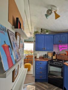 a kitchen with blue cabinets and a stove at Escape to the Mountain in Halkyn