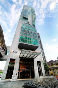 a tall building with a fountain in front of it at Eastin Grand Hotel Sathorn in Bangkok