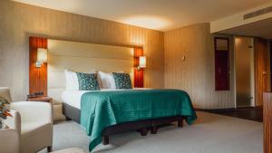 ein Hotelzimmer mit einem Bett und einem Stuhl in der Unterkunft Van der Valk Hotel Rotterdam - Blijdorp in Rotterdam