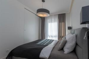 a bedroom with a bed and a large window at Very Stylish&Secure Penthouse -Free Parking in Łódź