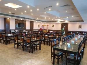 a restaurant with tables and chairs in a room at Liberty Resort in Puri