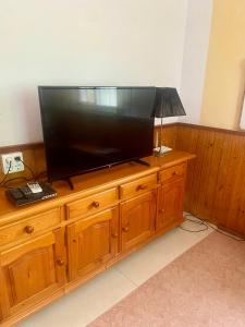 a large flat screen tv on a wooden entertainment center at Cute Little Casita in Mijas