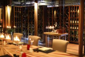 a room with a table and chairs and wine bottles at Coco Bodu Hithi - Stay 4 nights or more and enjoy 30 percent off Shared Roundtrip Speedboat, valid for stays until 31st August 2026 in Kudahitty +39 photos