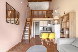 eine kleine Wohnung mit einer Treppe und gelben Stühlen in der Unterkunft Domaine de la Gaillarde in Roquebrune-sur-Argens