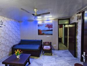 a living room with a bed and a ceiling fan at Peaceful stay in New Delhi
