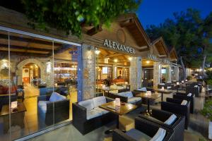 a restaurant with tables and chairs in front of a building at Alexander Beach Hotel & Village Resort in Malia