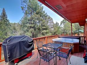 a deck with a grill and a table and chairs at Touch of Santa Fe in Ruidoso
