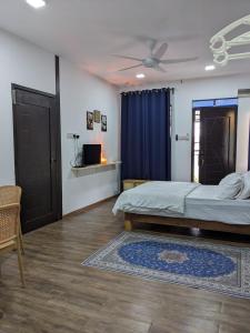 a bedroom with a bed and a ceiling fan at Rods Homestay - Kg Agong Penaga in Kepala Batas