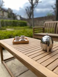 - une table en bois avec deux tasses et une théière dans l'établissement La Petite Maison Dans la Prairie - Havre de paix, à Rennes