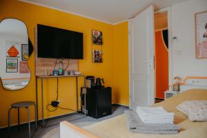 a bedroom with a tv on a yellow wall at sleepArt room for 1 in Celle