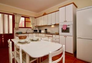 a kitchen with a white table and a white refrigerator at Angela Beach Place in Vila Baleira