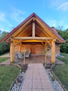 Cabaña de madera con terraza de madera y banco en Guest house Mihovil, en Slunj