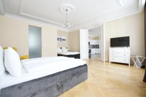 a white bedroom with a large bed and a television at Premium Apartment by Hi5 - Ferenciek tere - 3 BDR in Budapest