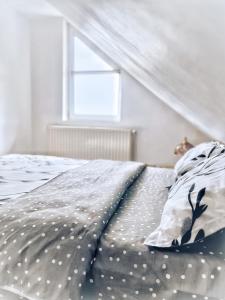 um quarto com uma cama com lençóis de bolinhas e uma janela em Pensiunea Colt de Rai, Vistisoara em Stațiunea Climaterică Sâmbăta