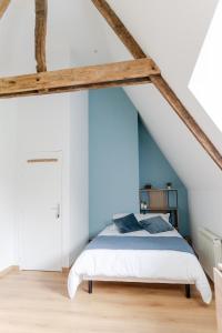 ein Schlafzimmer mit einem weißen Bett und blauen Wänden in der Unterkunft Studio à la campagne in Saint-Martin-le-Gaillard