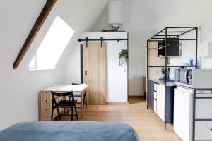 Zimmer mit einem Bett und einem Tisch sowie einer Küche in der Unterkunft Studio à la campagne in Saint-Martin-le-Gaillard