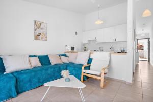 サンミゲル・デ・アボナにあるAmarilla Golf Apartmentのリビングルーム(青いソファ付)、キッチン
