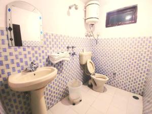 a bathroom with a sink and a toilet at The Lake Cottage by VRB Hotels in Dharamshala