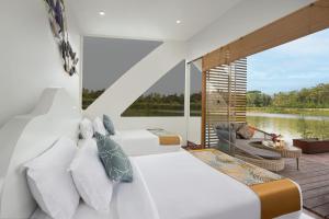 een slaapkamer met een bed en uitzicht op een meer bij Bolagala Agro Floating Resort in Negombo