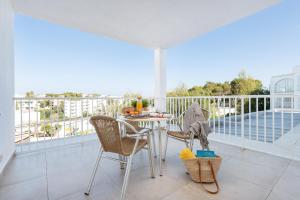 a patio with a table and chairs on a balcony at Apartamentos Ferrera Pins in Cala Ferrera