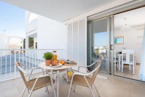 ein Esszimmer mit einem Tisch und Stühlen auf dem Balkon in der Unterkunft Apartamentos Ferrera Pins in Cala Ferrera