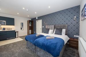 1 dormitorio con 1 cama grande con sábanas azules en Morecambe Bay Studio Apartments with Free Parking By Beach Front en Morecambe