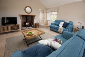 een woonkamer met een blauwe bank en een tafel bij Lyme Grass in Bamburgh