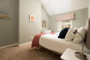 een slaapkamer met een groot wit bed en een raam bij Lyme Grass in Bamburgh