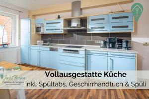 a kitchen with blue cabinets in a room at Residenz am Meer 24C Strandkrabbe in Juist