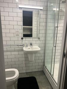 a white bathroom with a sink and a toilet at Studio Shoreditch in London