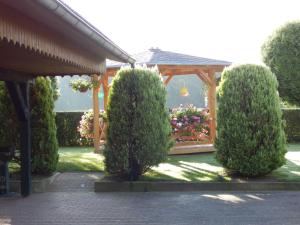 einen Garten mit einem Pavillon und einigen Büschen in der Unterkunft Ferienwohnung unweit der Müritz in Gotthun