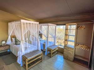a bedroom with a canopy bed and a window at African Dream Tour in Hoedspruit