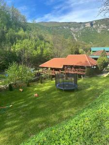 uma casa com um parque infantil num campo de relva em ŽUBOR VRELA em Despotovac